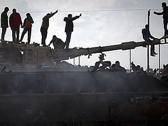 Противники Муамара Каддафи на разбомбленном авиацией НАТО правительственном танке. Фото с сайта www.toledoblade.com