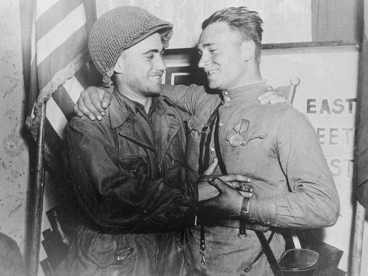 Лейтенант У.Робертсон и лейтенант А.С.Сильвашко на фоне надписи «Восток встречается с Западом», город Торгау близ реки Эльба, 26 апреля 1945 года