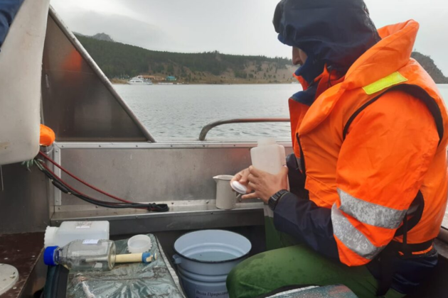 Сотрудник лаборатории берет пробы воды в Байкале