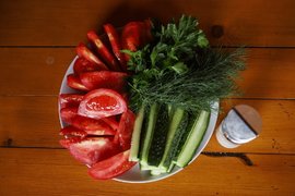 Огурцы, помидоры и зелень на тарелке