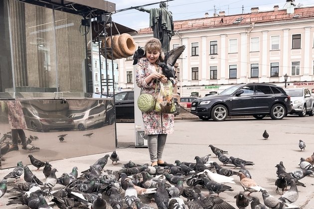 Женщина кормит голубей