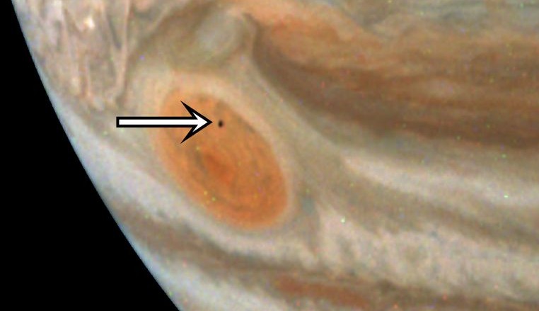 Амальтея на фоне Большого красного пятна на Юпитере