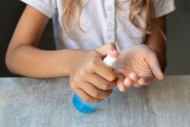 Девочка наносит репеллент