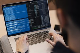 Студент пишет код на компьютере