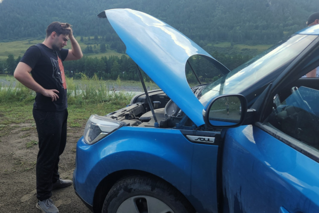 Парень стоит перед открытым капотом