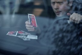 Мужчина за рулем с лекарством в руке