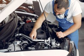 Мужчина чинит автомобиль