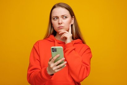 Девушка задумалась с телефоном